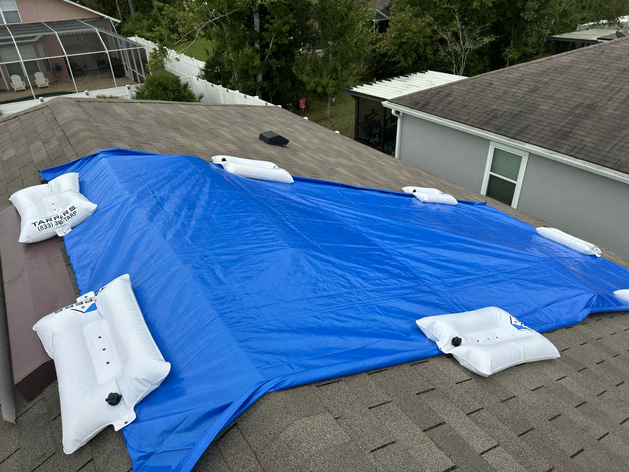 TarpBags installed on a residential roof showing the non penetrating anchor system in use